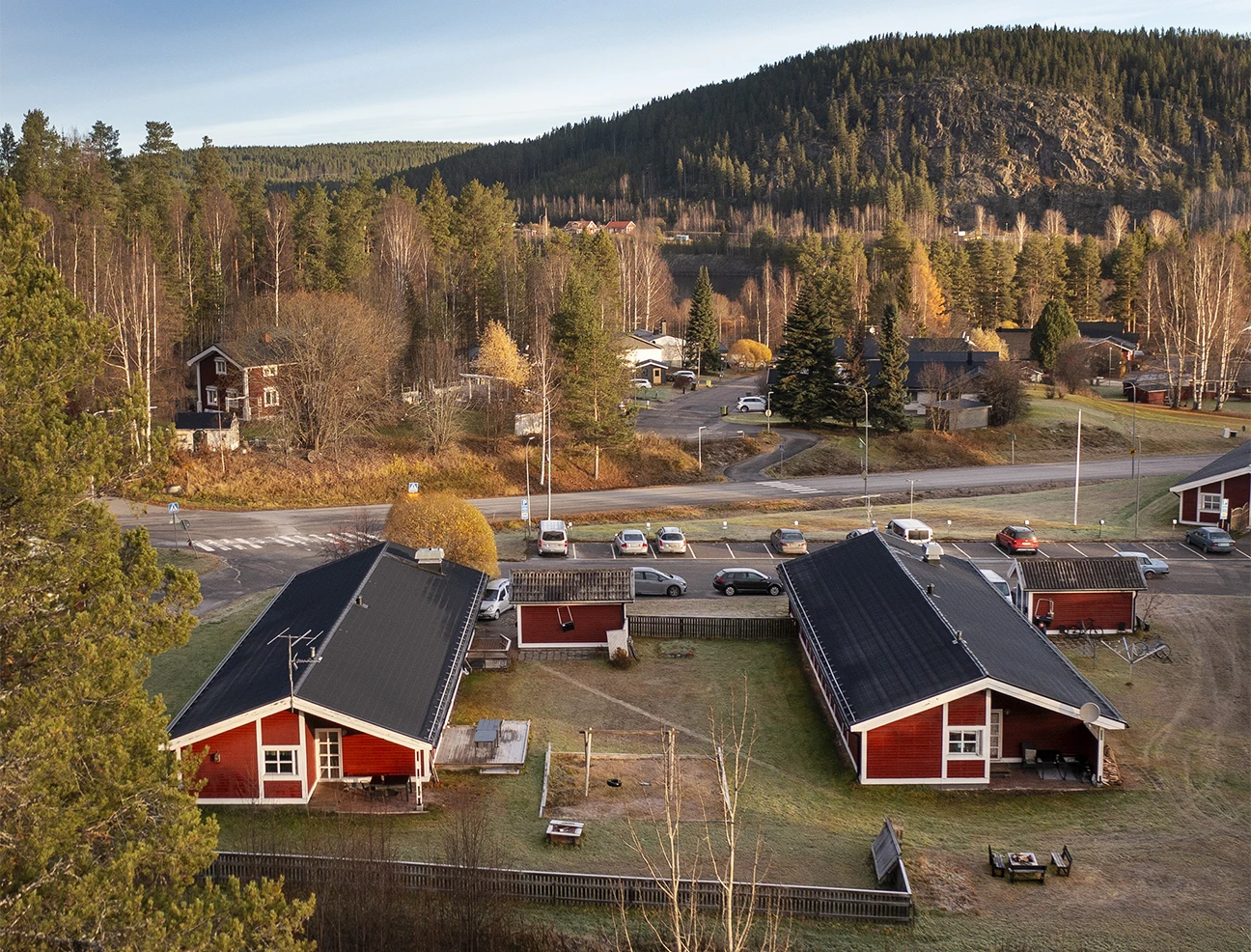 Avstampets behandlingshem i Älvsbyn sett från ovan – två röda hus med skog och berg i bakgrunden